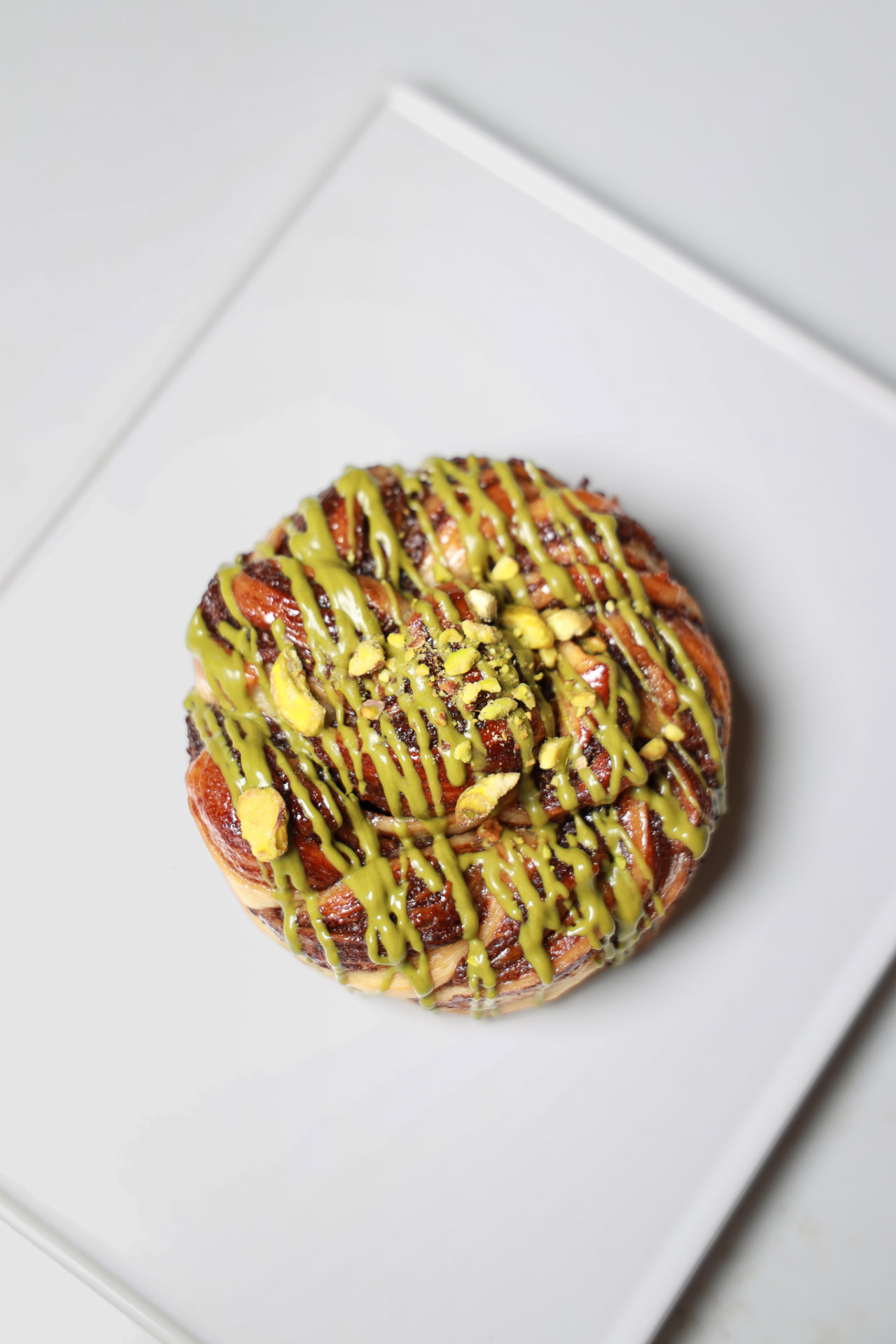 Pistachio Twist pastry on a ceramic plate
